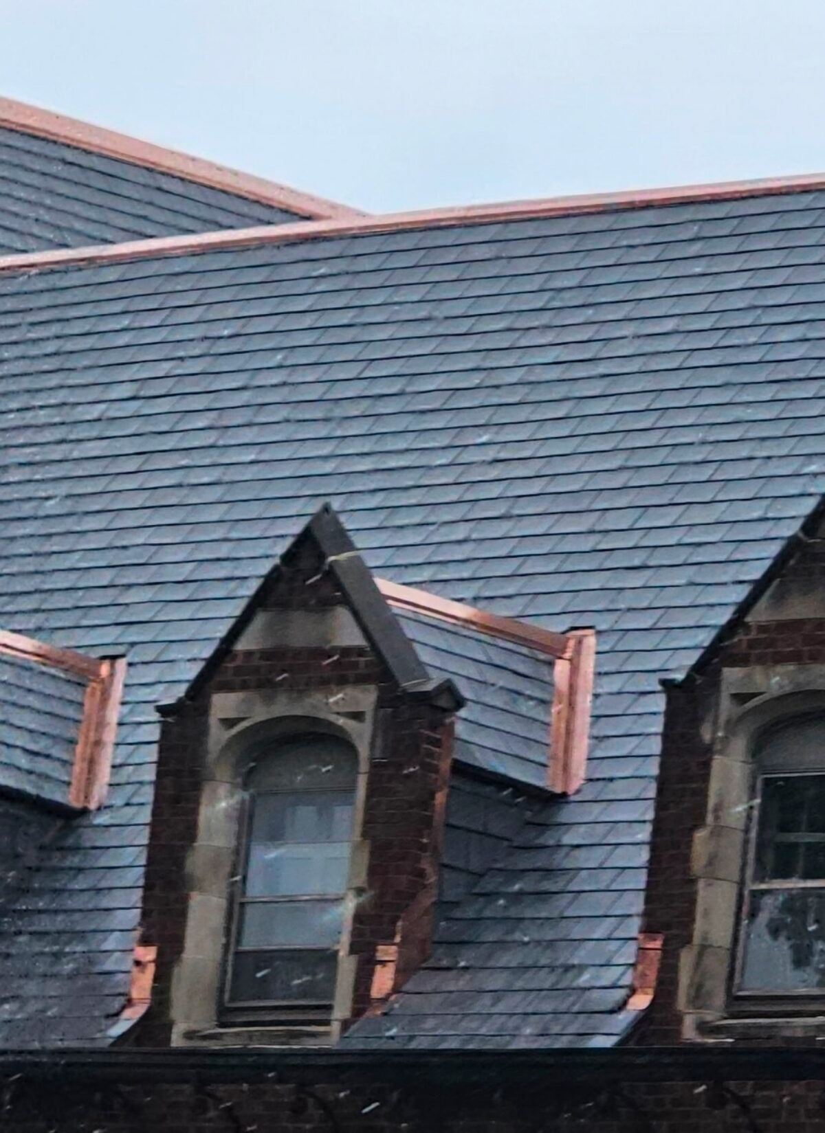 Close-up of a natural slate roof with new copper dormer flashing on a historic St. Louis home