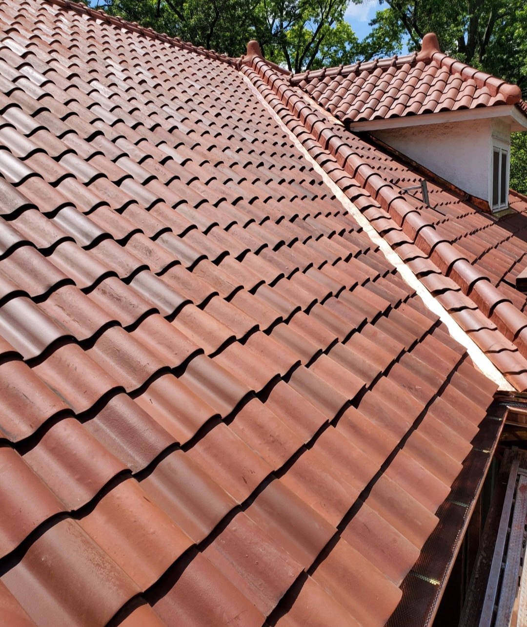 Clay tile roof valley and ridge detail showing precise craftsmanship