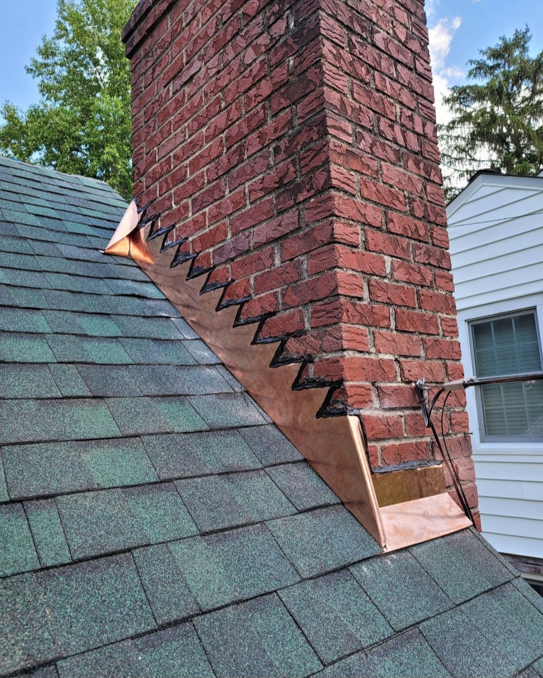 Custom copper flashing detail on asphalt shingle roof